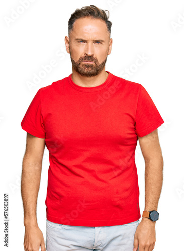 Handsome middle age man wearing casual red tshirt skeptic and nervous, frowning upset because of problem. negative person.