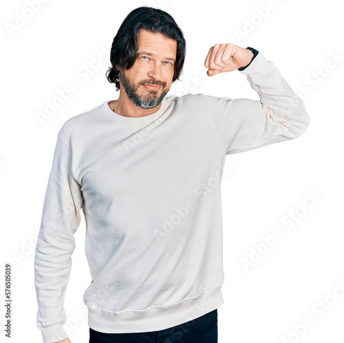 Middle age caucasian man wearing casual clothes strong person showing arm muscle, confident and proud of power