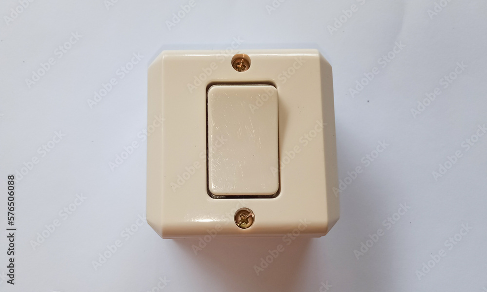 A light switch or saklar, a plastic mechanical switch of white color on a white background. A light switch or saklar, a plastic mechanical switch of white color on a white background.