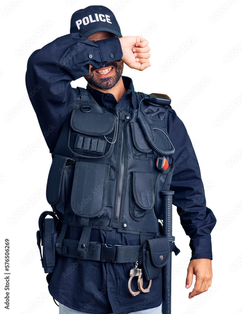 Young hispanic man wearing police uniform covering eyes with arm smiling cheerful and funny. blind concept. Young hispanic man wearing police uniform covering eyes with arm smiling cheerful and funny. blind concept.