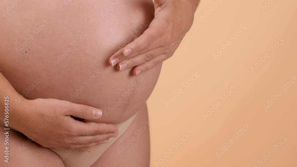 Pregnancy body care. Close up of pregnant woman big belly, unrecognizable expectant lady rubbing pampering cream on skin Pregnancy body care. Close up of pregnant woman big belly, unrecognizable expectant lady rubbing pampering cream on skin