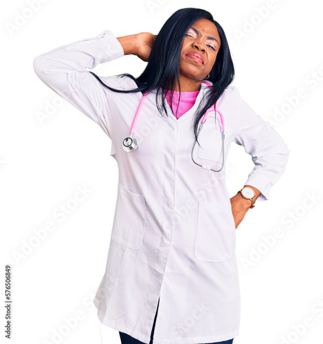 Young african american woman wearing doctor stethoscope suffering of neck ache injury, touching neck with hand, muscular pain