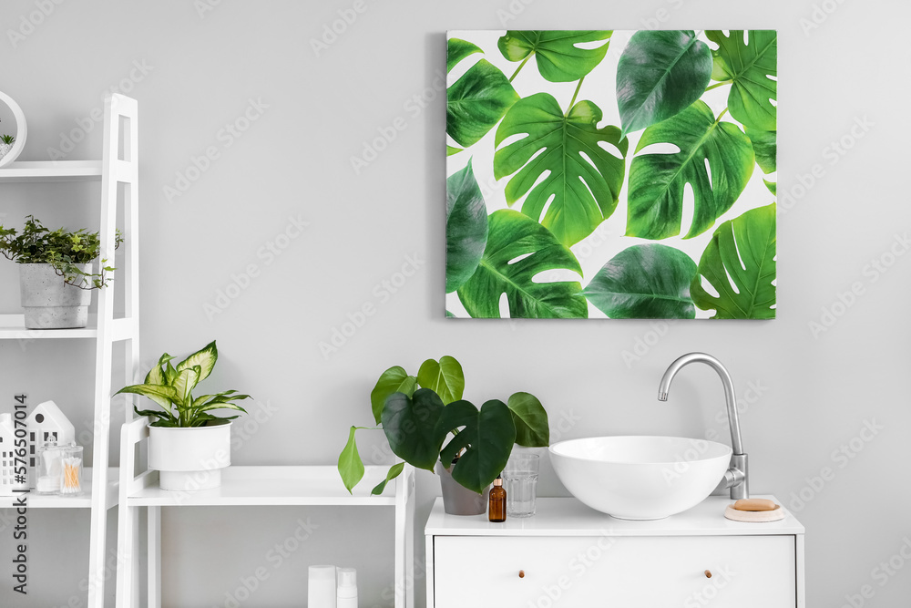 Obraz premium Interior of light bathroom with sink, shelving units and houseplants