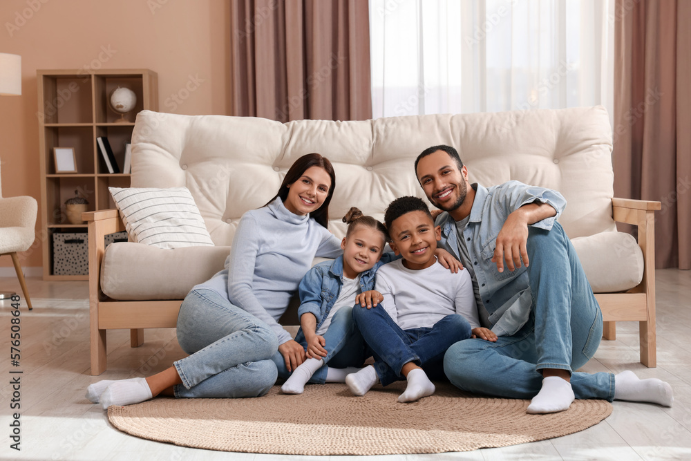 Happy international family with children near sofa at home Happy international family with children near sofa at home