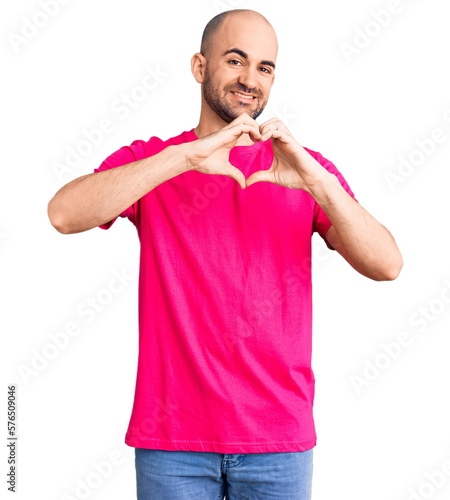 Young handsome man wearing casual t shirt smiling in love doing heart symbol shape with hands. romantic concept.