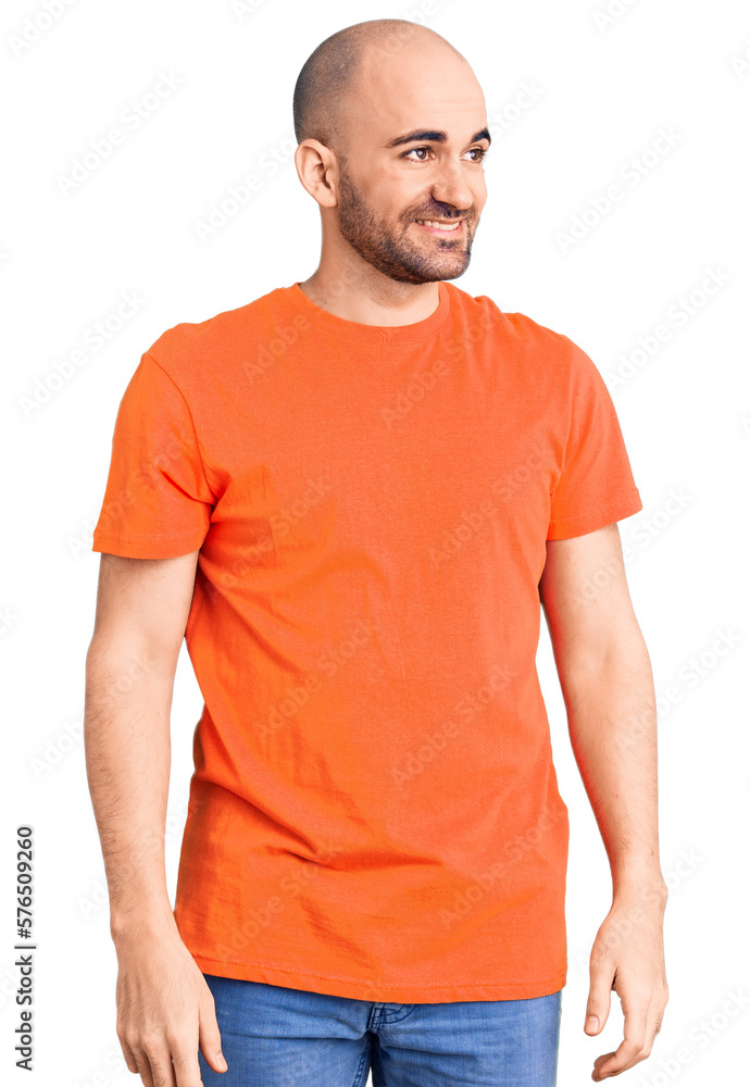 Fototapeta premium Young handsome man wering casual t shirt looking away to side with smile on face, natural expression. laughing confident.