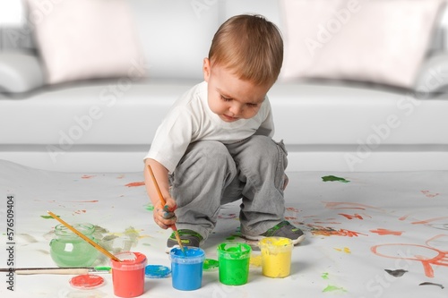 Cute little child drawing on floor at home