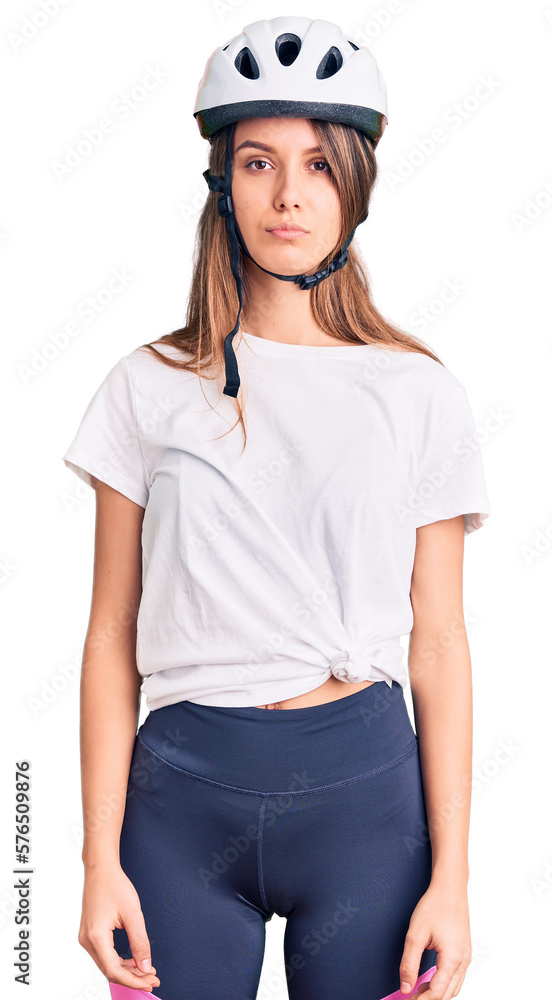 Young beautiful girl wearing bike helmet with serious expression on face. simple and natural looking at the camera. Young beautiful girl wearing bike helmet with serious expression on face. simple and natural looking at the camera.