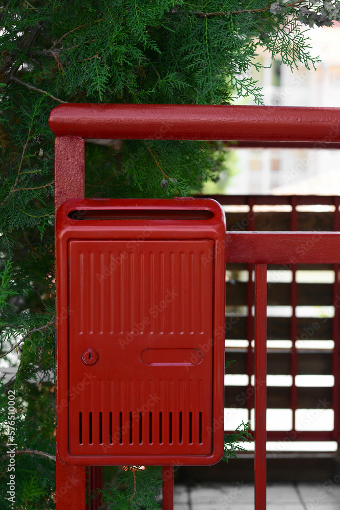 Red beautiful metal letter box near tree outdoors Red beautiful metal letter box near tree outdoors