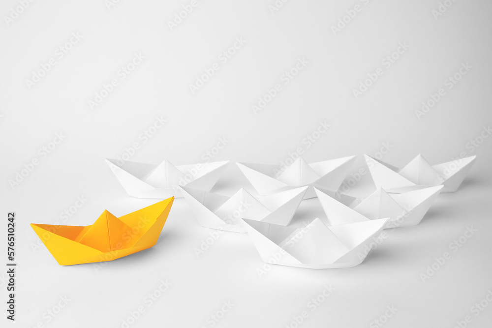 Group of paper boats following orange one on white background. Leadership concept Group of paper boats following orange one on white background. Leadership concept