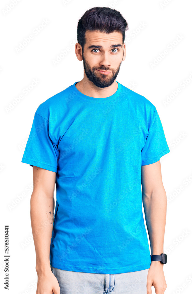 Young handsome man with beard wearing casual t-shirt skeptic and nervous, frowning upset because of problem. negative person. Young handsome man with beard wearing casual t-shirt skeptic and nervous, frowning upset because of problem. negative person.