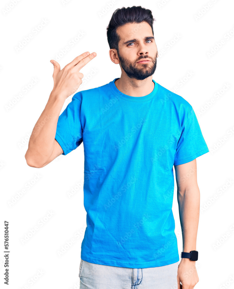 Young handsome man with beard wearing casual t-shirt shooting and killing oneself pointing hand and fingers to head like gun, suicide gesture. Young handsome man with beard wearing casual t-shirt shooting and killing oneself pointing hand and fingers to head like gun, suicide gesture.