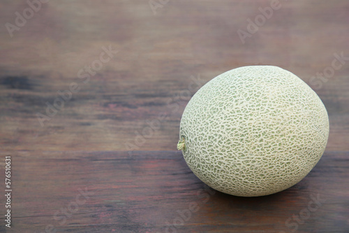 Whole ripe melon on wooden table. Space for text