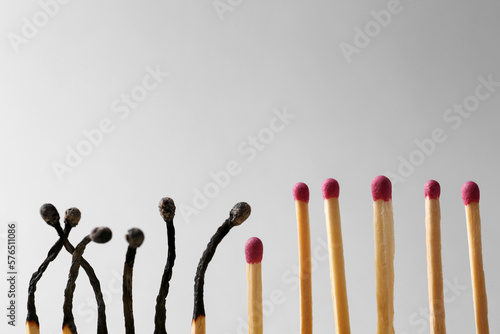 Burnt and whole matches on light grey background. Space for text