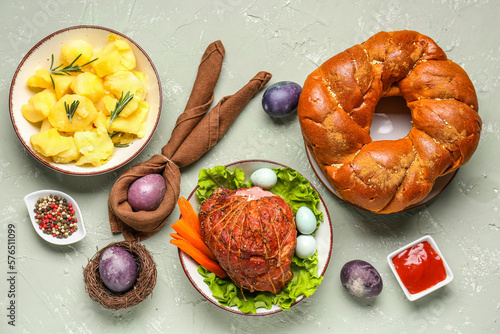 Tasty dishes and beautiful painted eggs for Easter dinner on grunge background