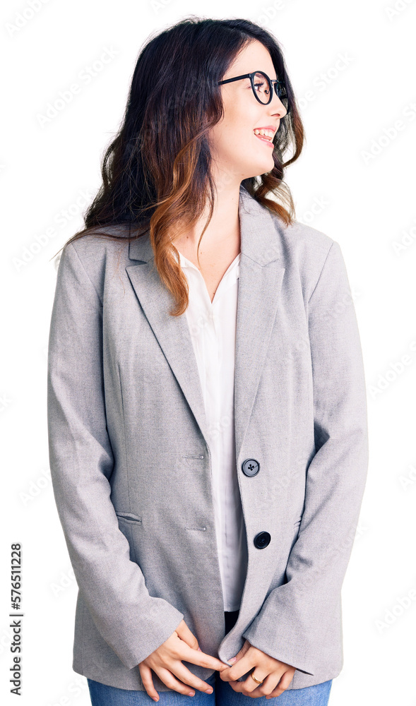 Beautiful young brunette woman wearing business clothes and glasses looking away to side with smile on face, natural expression. laughing confident.