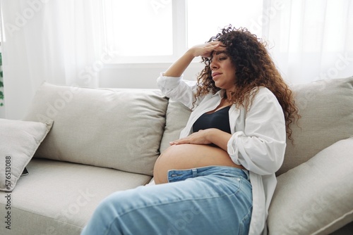 Pregnant woman headache lies at home on the couch fatigue and heaviness in the last month of pregnancy before childbirth, motherhood difficulties, nausea