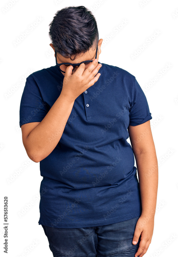 Little boy kid wearing casual clothes and glasses tired rubbing nose and eyes feeling fatigue and headache. stress and frustration concept.