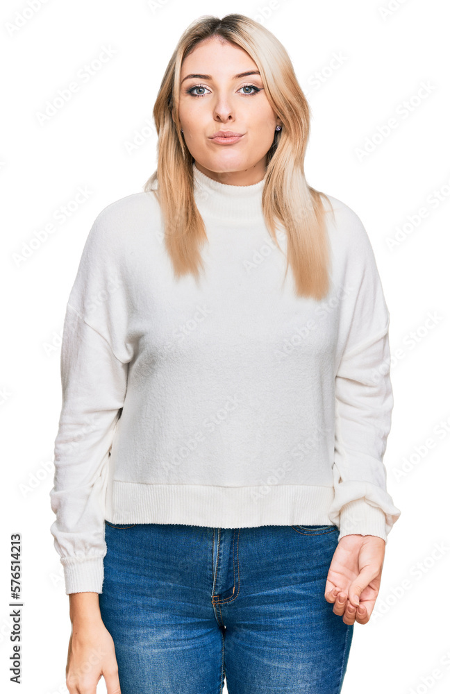 Young caucasian woman wearing casual winter sweater looking at the camera blowing a kiss on air being lovely and sexy. love expression. Young caucasian woman wearing casual winter sweater looking at the camera blowing a kiss on air being lovely and sexy. love expression.