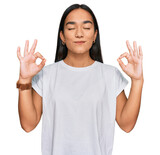 Young asian woman wearing casual white t shirt relax and smiling with eyes closed doing meditation gesture with fingers. yoga concept.