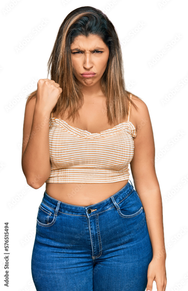 Beautiful brunette woman wearing casual clothes angry and mad raising fist frustrated and furious while shouting with anger. rage and aggressive concept. Beautiful brunette woman wearing casual clothes angry and mad raising fist frustrated and furious while shouting with anger. rage and aggressive concept.