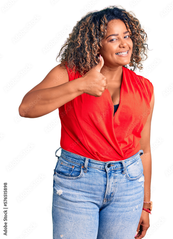 Young african american plus size woman wearing casual style with sleeveless shirt doing happy thumbs up gesture with hand. approving expression looking at the camera showing success. Young african american plus size woman wearing casual style with sleeveless shirt doing happy thumbs up gesture with hand. approving expression looking at the camera showing success.