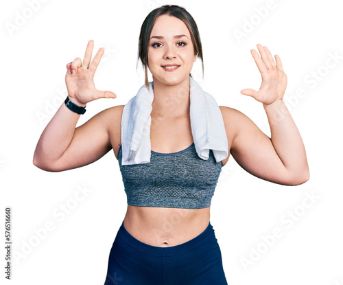 Young hispanic girl wearing sportswear and towel showing and pointing up with fingers number eight while smiling confident and happy.