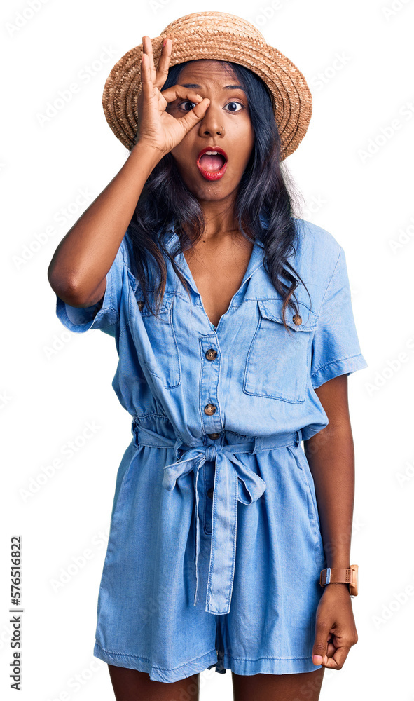 Young indian girl wearing summer hat doing ok gesture shocked with surprised face, eye looking through fingers. unbelieving expression. Young indian girl wearing summer hat doing ok gesture shocked with surprised face, eye looking through fingers. unbelieving expression.