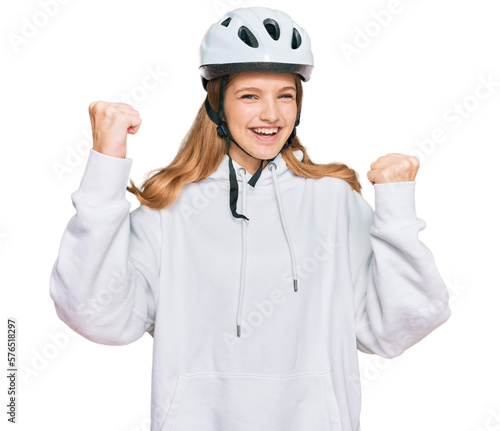 Beautiful young caucasian girl wearing bike helmet screaming proud, celebrating victory and success very excited with raised arms © Krakenimages.com