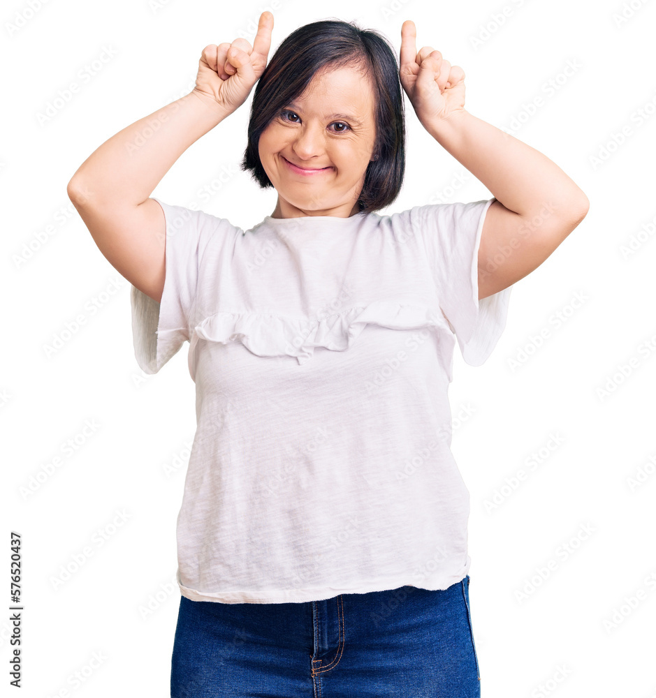 Brunette woman with down syndrome wearing casual white tshirt doing funny gesture with finger over head as bull horns Brunette woman with down syndrome wearing casual white tshirt doing funny gesture with finger over head as bull horns