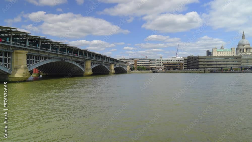 POV view of the London Thames standing by the fence many iconic historical buildings Canary Wharf in the background sunny day with clouds birds flying moving motion to the side cinematic POV view of the London Thames standing by the fence many iconic historical buildings Canary Wharf in the background sunny day with clouds birds flying moving motion to the side cinematic