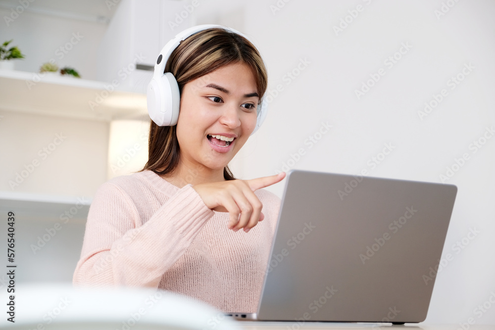 Young asian woman with headphones while make video conference by laptop computer Young asian woman with headphones while make video conference by laptop computer