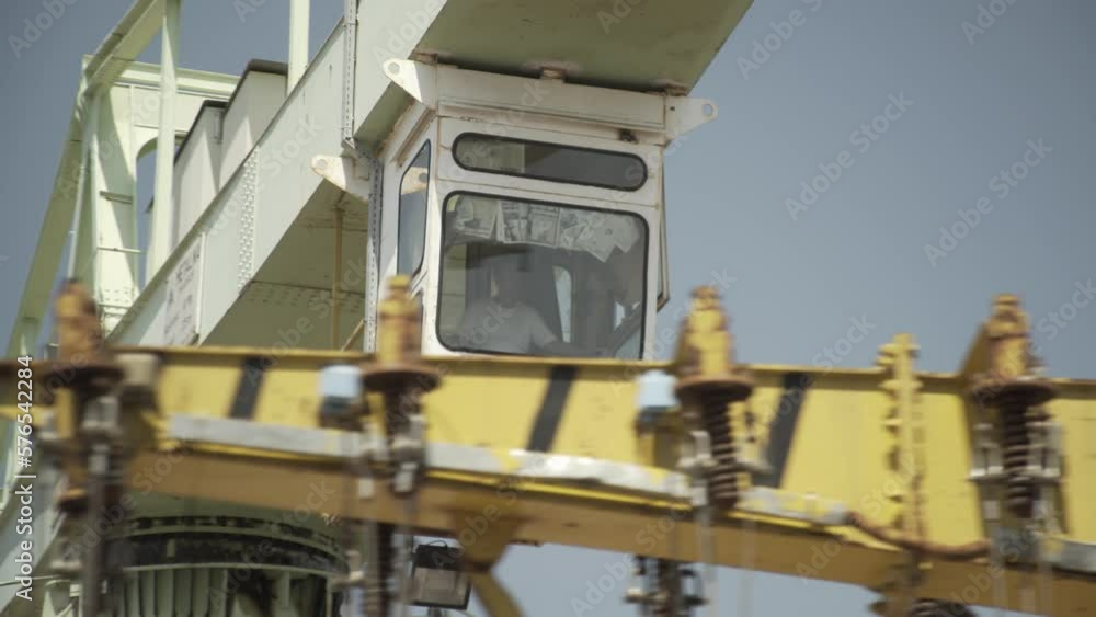 Shipyard. A worker operates a large crane. Shipyard. A worker operates a large crane.