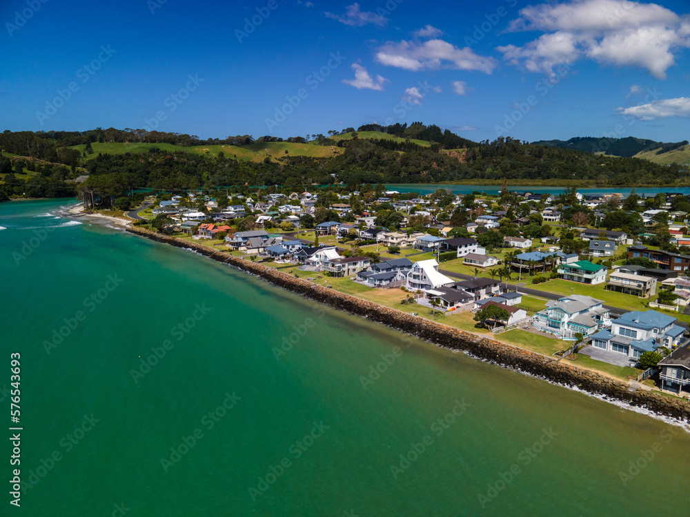 Luxury beach front properties in coastal town with swirling low tide patterns in the sand seen from above.