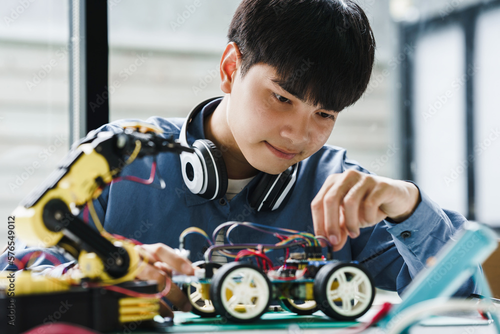 Asian teenager students doing robot arm and robotic cars homework ...