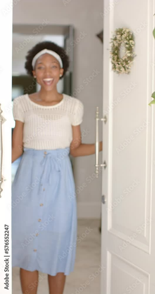 Vertical video of portrait of happy african american woman opening door, in slow motion Vertical video of portrait of happy african american woman opening door, in slow motion