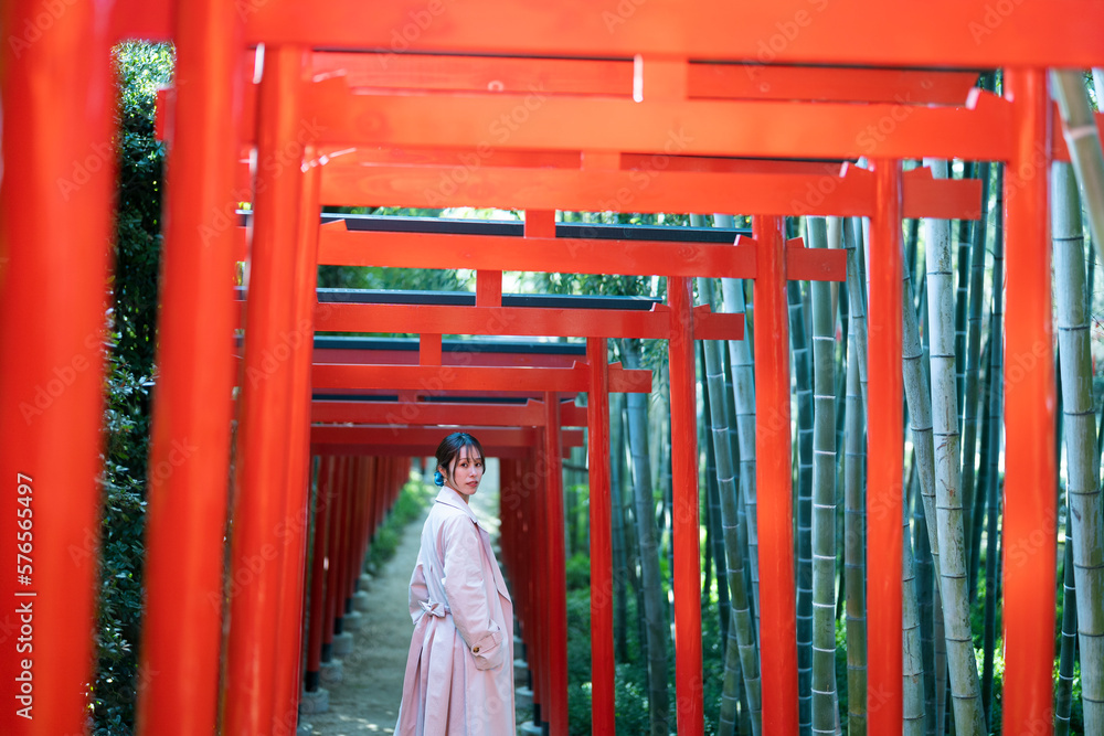 赤い鳥居をくぐる女性