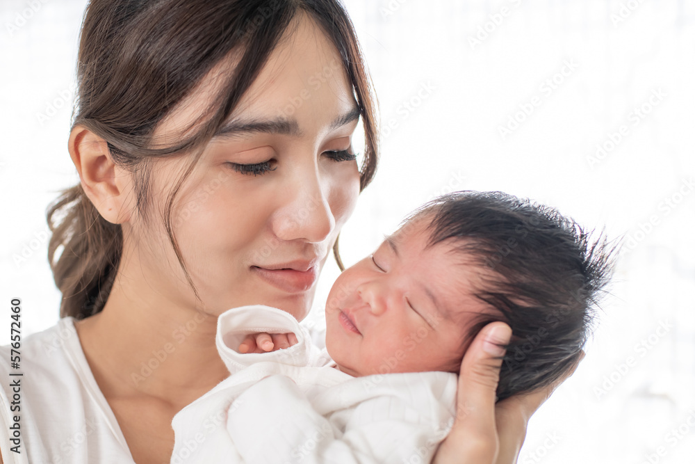 happy loving family. mother playing with her baby hugging in the bedroom , portrait of asian mother playing with newborn baby, health care family love together. asian girl lifestyle.. happy loving family. mother playing with her baby hugging in the bedroom , portrait of asian mother playing with newborn baby, health care family love together. asian girl lifestyle..