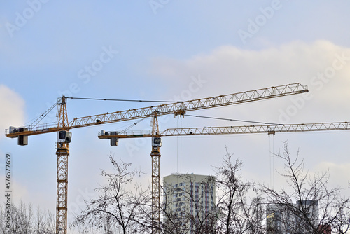 Two cranes on a construction site on a winter day