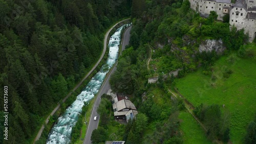 Aerial View Of Torrente Aurino River With Pan Up To Reveal Taufers Castle In Forested Valley Hills Of South Tyrol photo