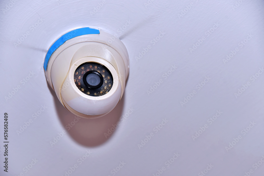 CCTV security camera on white wall background with copy space for text. CCTV security camera on white wall background with copy space for text.