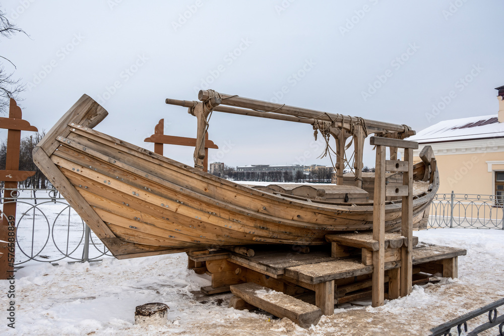 an old wooden boat in the old center made according to the technologies of the past in Veliky Novgorod on a winter day