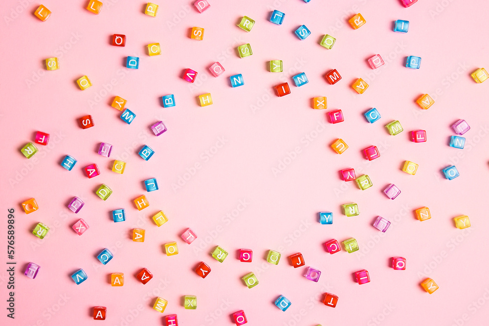 Round frame from colorful letter beads on pink background. Flat lay, copy space. Round frame from colorful letter beads on pink background. Flat lay, copy space.