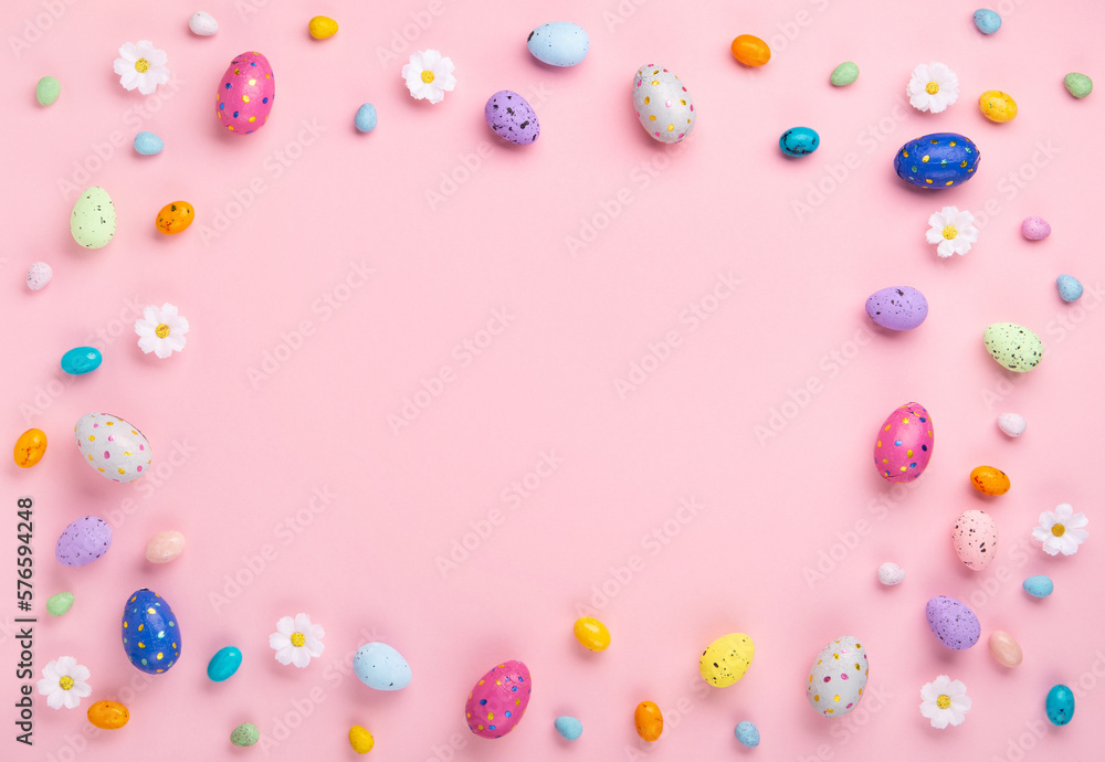 Easter Eggs with Sweets and Spring Flowers on Pink Background