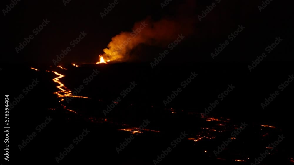 Epic view of lava fountain shooting up into air from Hawaii Mauna Loa volcano eruption of 2022. Red orange yellow glowing hot lava and magma erupting out of volcano at night. Dramatic shot RED camera Epic view of lava fountain shooting up into air from Hawaii Mauna Loa volcano eruption of 2022. Red orange yellow glowing hot lava and magma erupting out of volcano at night. Dramatic shot RED camera