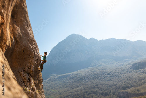 Girl climbing rocks, rock climbing. like sports and recreation. sports girl is engaged in rock climbing.