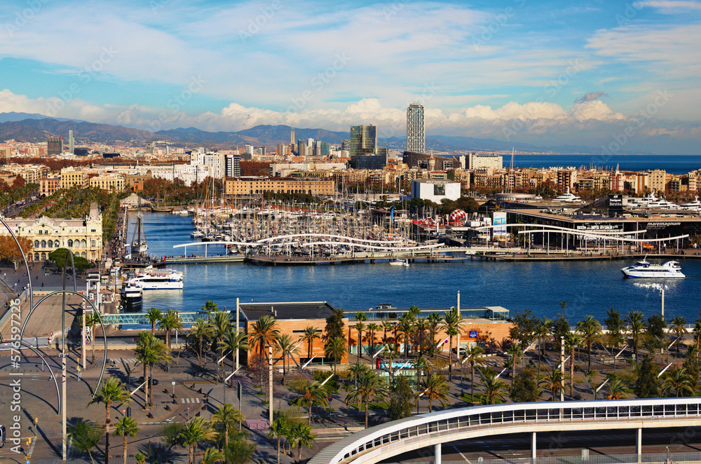 Barcelona, Spain-January 02,2016:Scenic aerial landscape view of Port Vell with moored yachts and ships, Maremagnum shopping mall. Downtown of Barcelona in the background. Travel and tourism concept