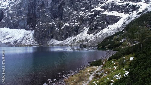 Czarny Staw pod Rysamy or Black Pond lake near the Morskie Oko Snowy Mountain Hut in Polish Tatry mountains, drone view, Zakopane, Poland. Aerial view shot of beautiful green hills and mountains in