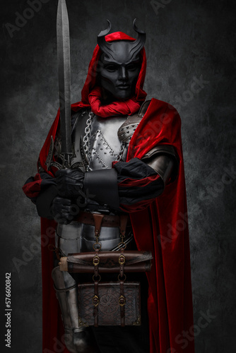 Принти на полотні Shot of leader of esoteric cult dressed in silver armor and red mantle with horned mask