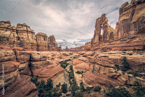 A sandstone arch stands about a desert scene.